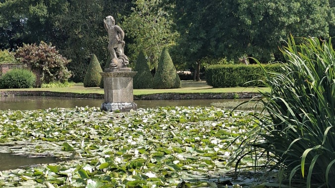 A statue of the god Neptune and lily pads at Westbury Court Garden